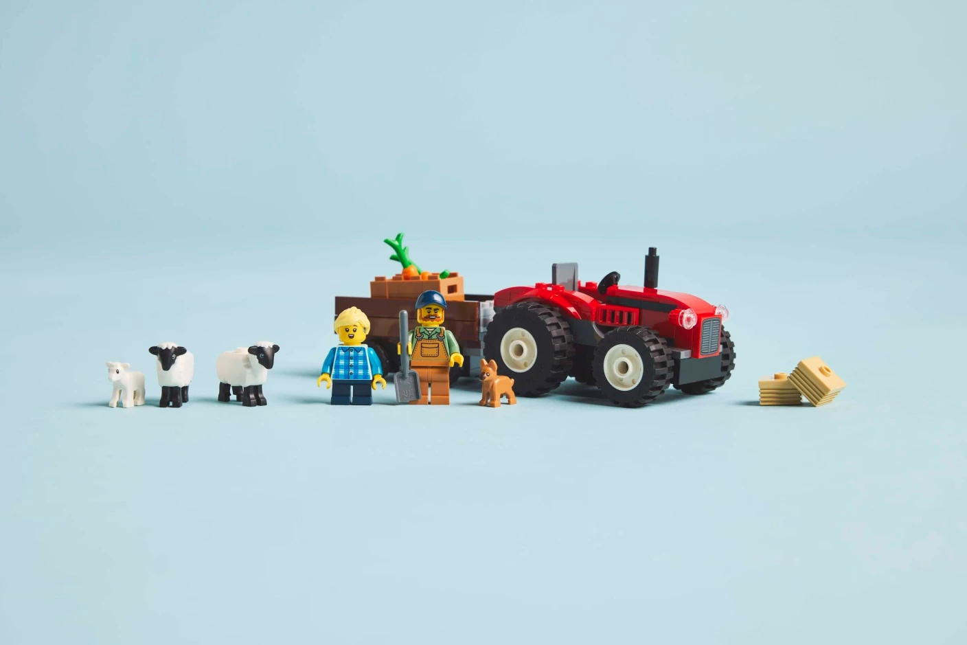 Rode tractor met aanhanger en schapen